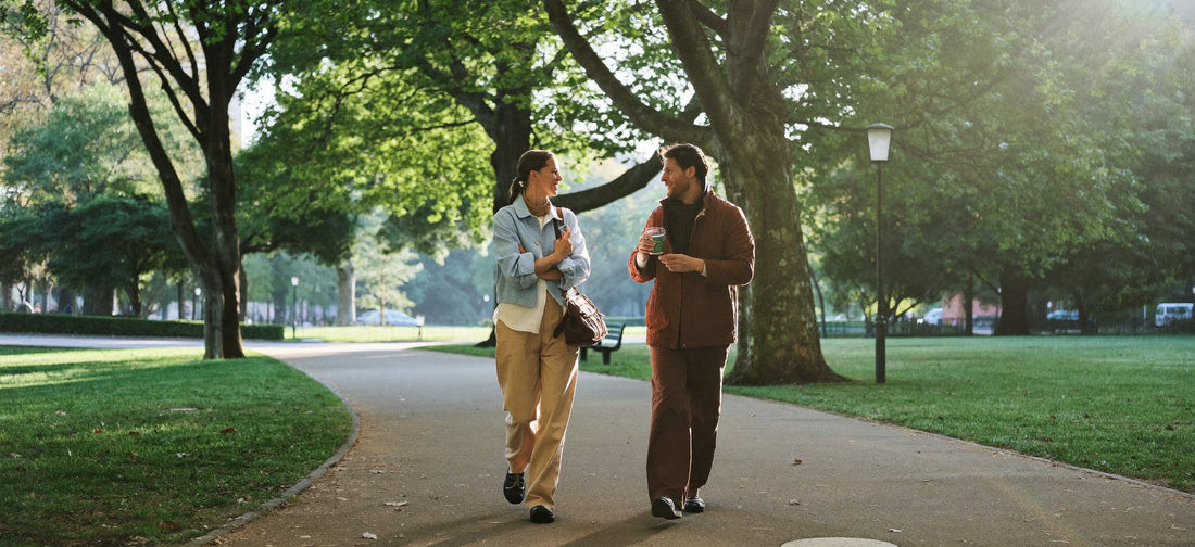 Two young adults enjoying a relaxed walk on a sunny urban park path