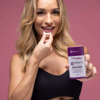 Woman holding and about to take Femina™ Probiotic Capsules with Cranberry Extract for intimate health and freshness