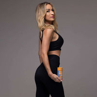 fit woman in black activewear holding GutSlim Probiotics fat burner supplement for gut health and weight loss
